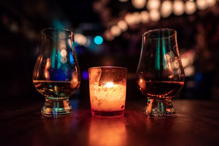 “selective focus photography of two clear footed glasses placed near votive candle on table” by Andrew Seaman on Unsplash